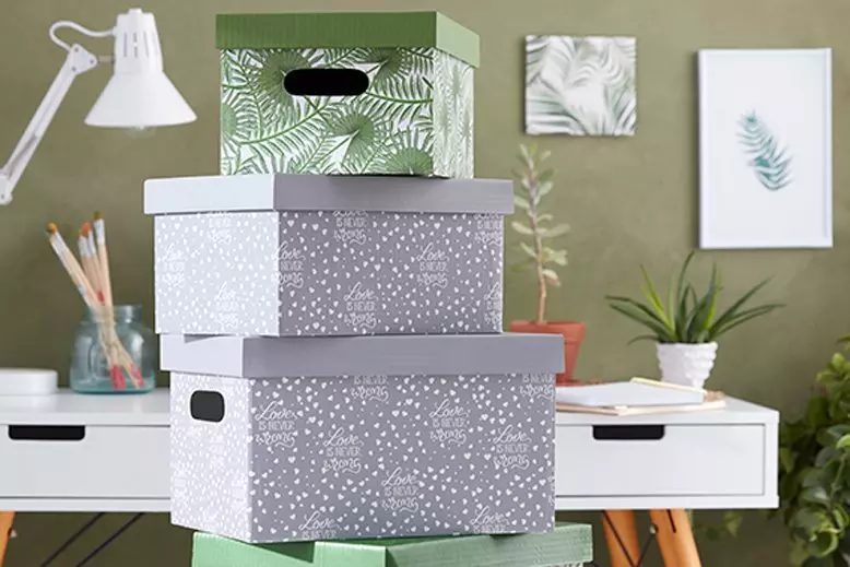 Skládané úložné boxy s vzory na bílém stole.