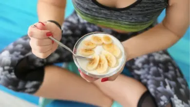 Žena v sportovní oblečení jí jogurt s banány bez počítání kalorií