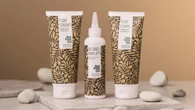 Tři lahvičky péče o vlasy značky Tea Tree Oil na mramoru.