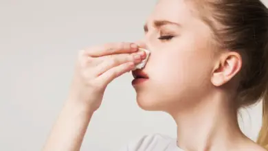 Dívka se otírá nos vaku. Případně: Dívka si čistí nos kapesníkem.
