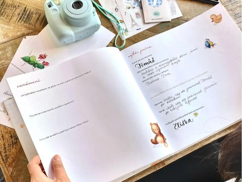 Otevírání knihy pro výběr jména miminka s fotoaparátem.