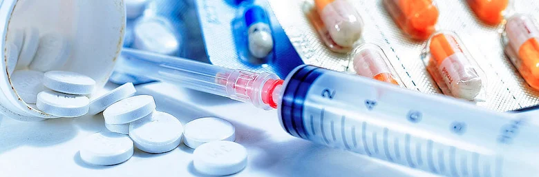 Střikadla s jehlou a bílé tablety na sportovní doping