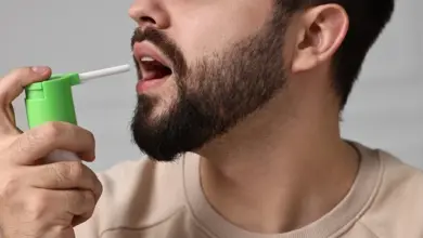 Muž používá zelený nosní zavlažovací přístroj pro bolest hrdla.