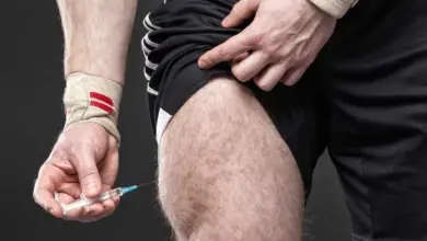 Muž podává injekci testosteronu do stehna pomocí špičky.