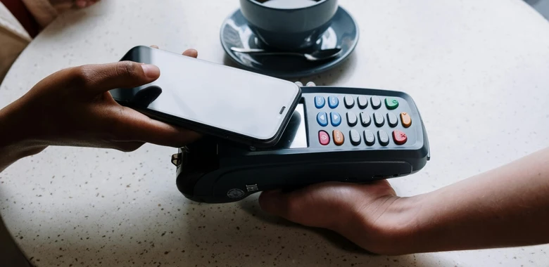 NFC platba telefonem na terminálu v kavárně