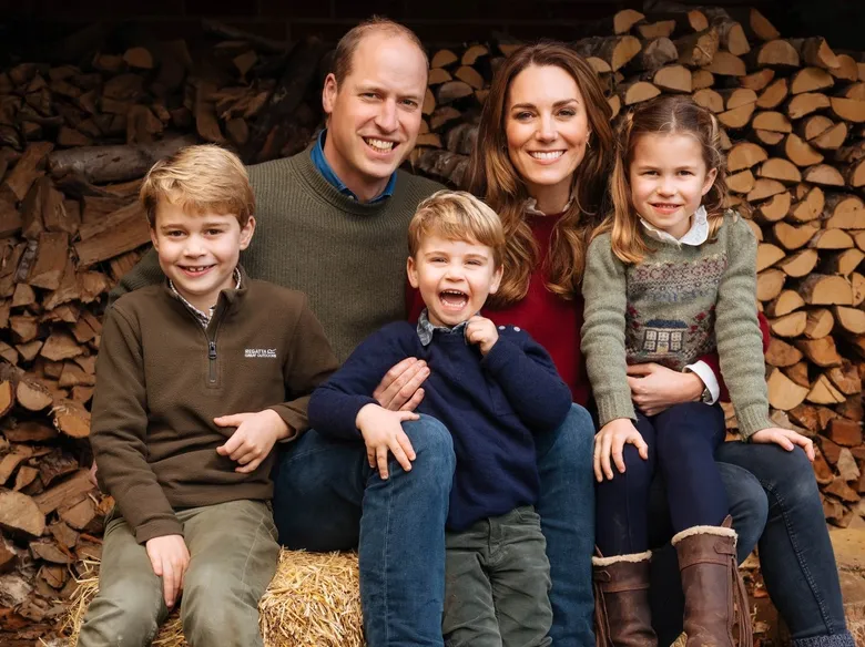 Princ William s Kate a jejich tři děti sedí na slámě.