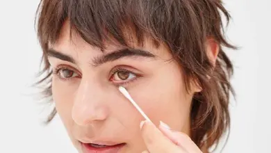 Žena aplikuje bavlněnou tyčinku pod oční víčko.