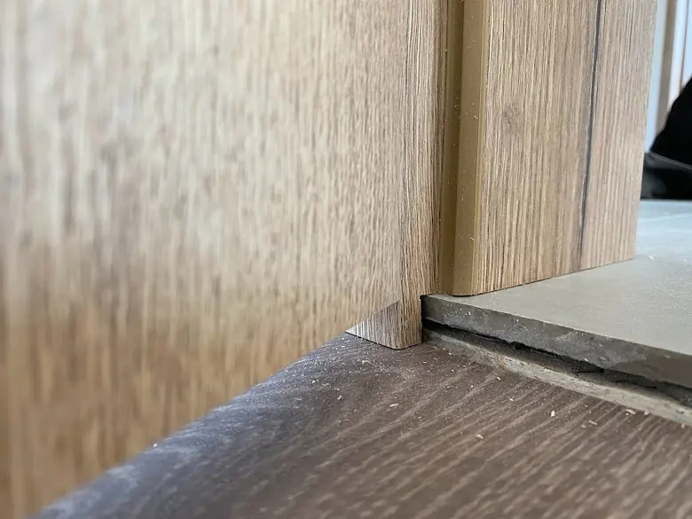 Detailní pohled na správně namontovaný dřevěný zárubňový roh u podlahy.