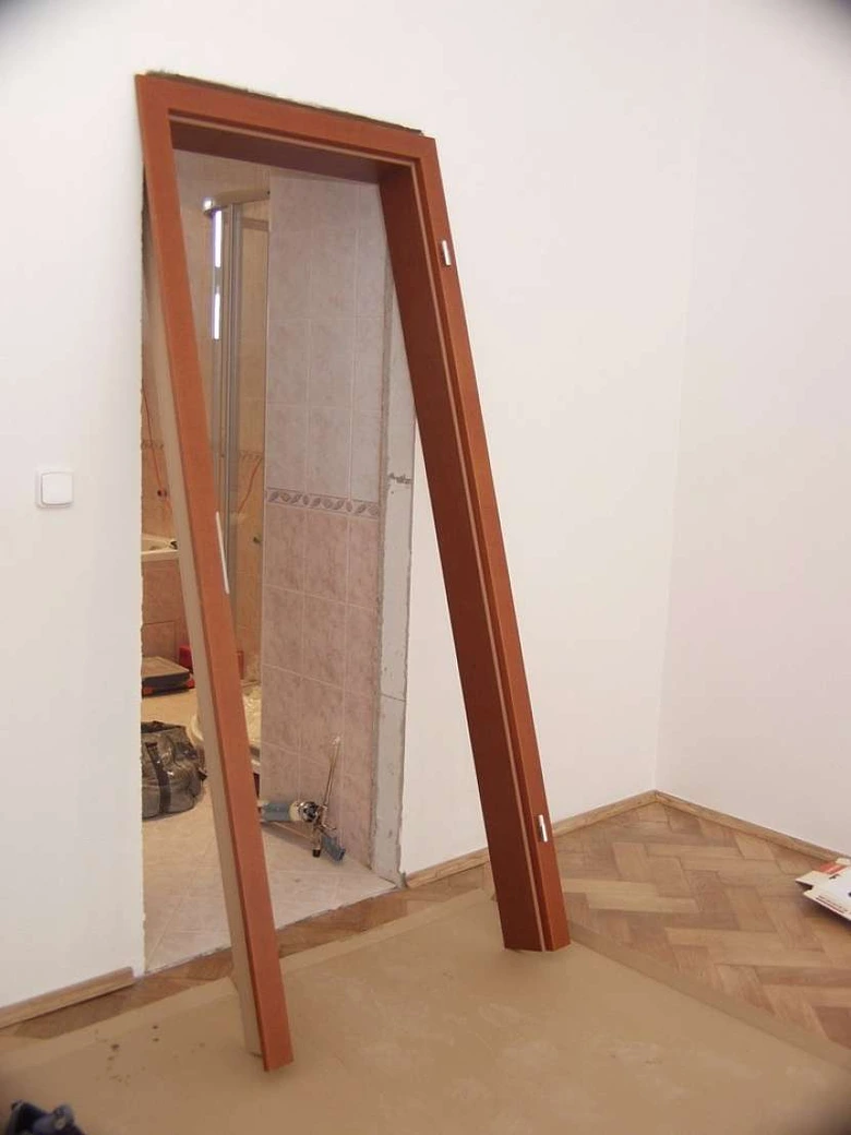 Dřevěný zárubňový rám stojí v interiéru před montáží.