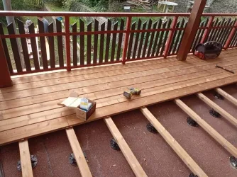Dřevěná terasa v procesu stavby s viditelnými trámy.